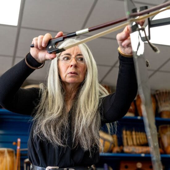 Evelyn demonstrates how to play a Thundersheet at a 'Who's Listening' workshop.