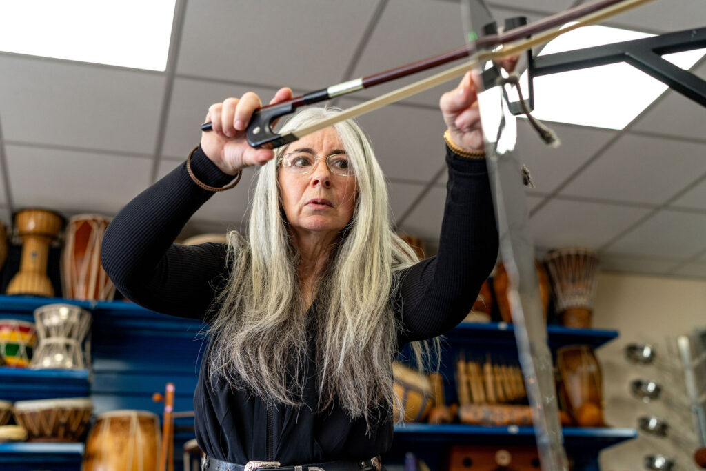 Evelyn demonstrates how to play a Thundersheet at a 'Who's Listening' workshop.