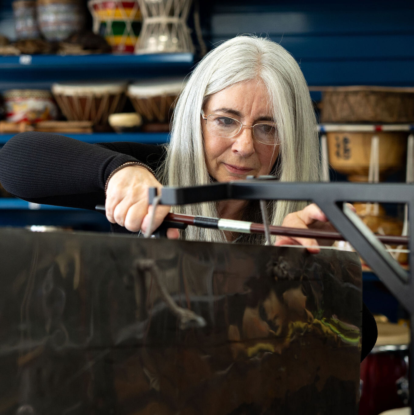 Evelyn demonstrates how to play a Thundersheet at a 'Who's Listening' workshop.